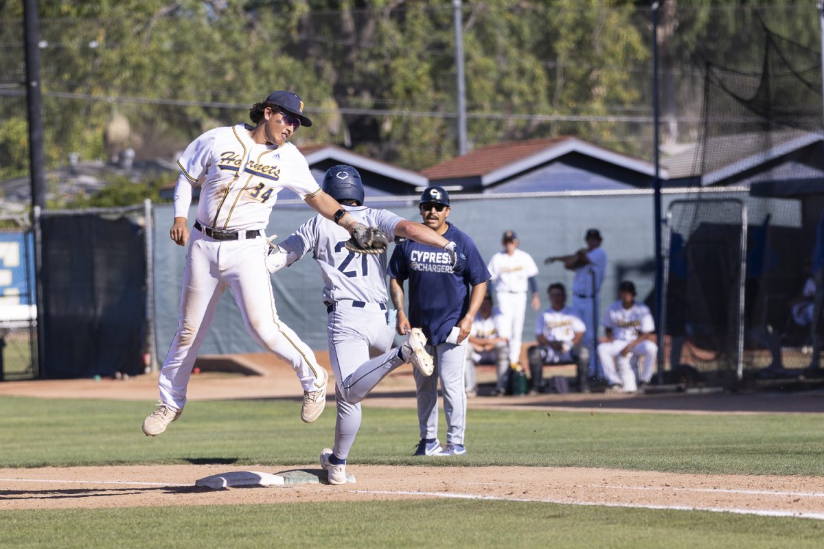 Fullerton's Carlos Barrios attempts to swipe tag Cypress right fielder Wyatt Joyce during the Don Hudson Scholarship Game on March 12, 2026, at Hornet Field in Fullerton, Calif.