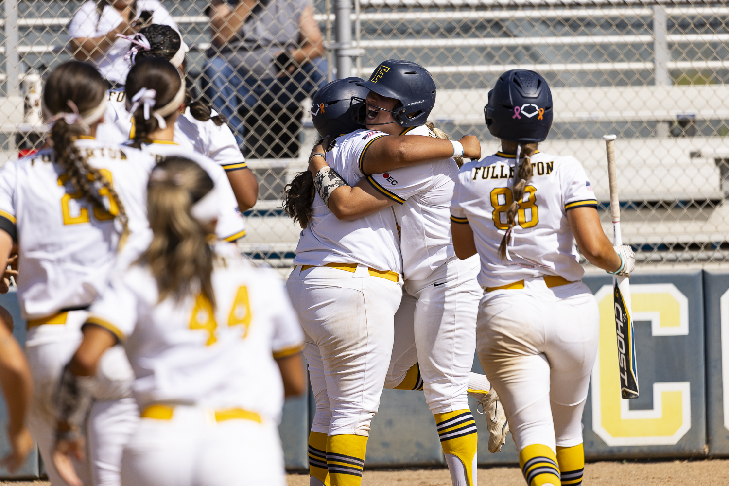 Lisa Villanueva of Fullerton, celebrates at home plate after her second home run of the game in the fourth inning, as her teammates rush in from the dugout against Santa Ana College on March 27, 2026, at Hornet Softball Field in Fullerton, Calif.