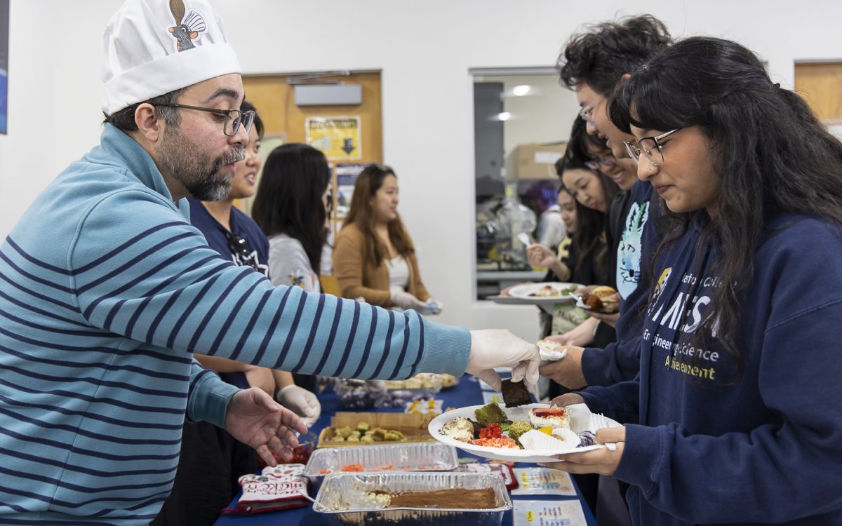 Alexander Brown (left), director and PDSO of Fullerton College’s International Student Center, serves a FC student a plate with a sample of each dessert.