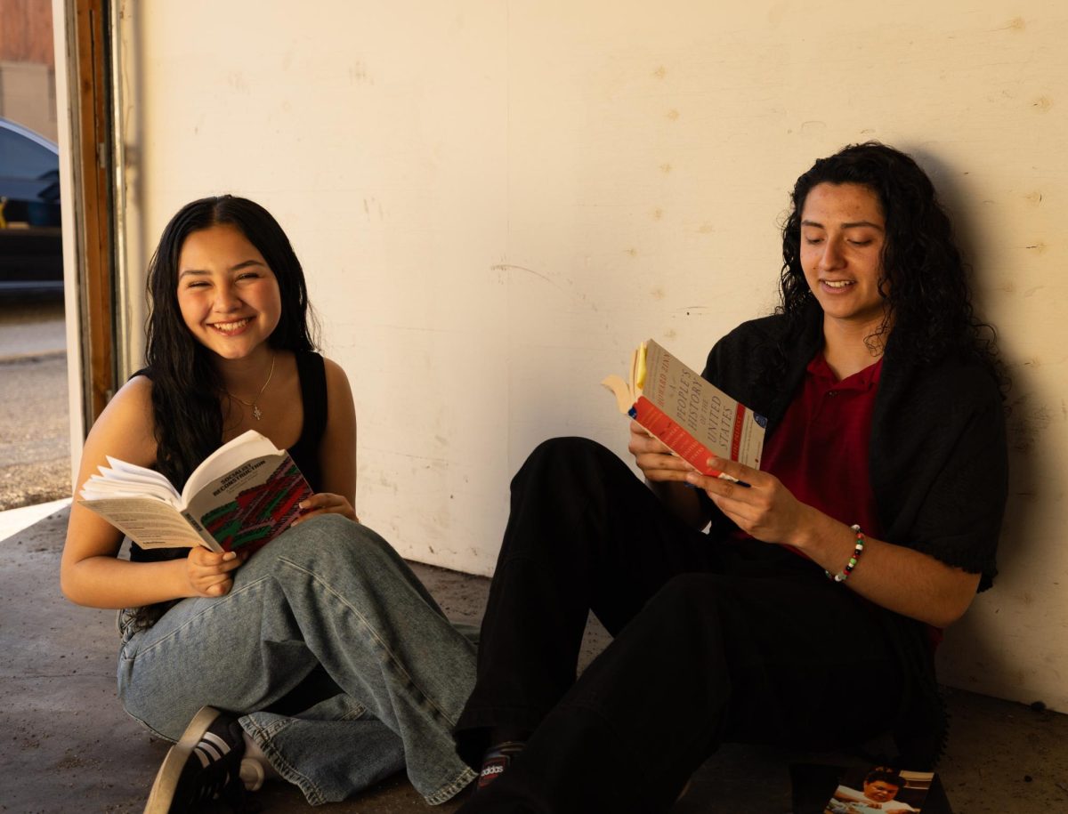 Jaden and Ariane Tagle sit on the floor, looking back at the books that inspire them to keep fighting. 