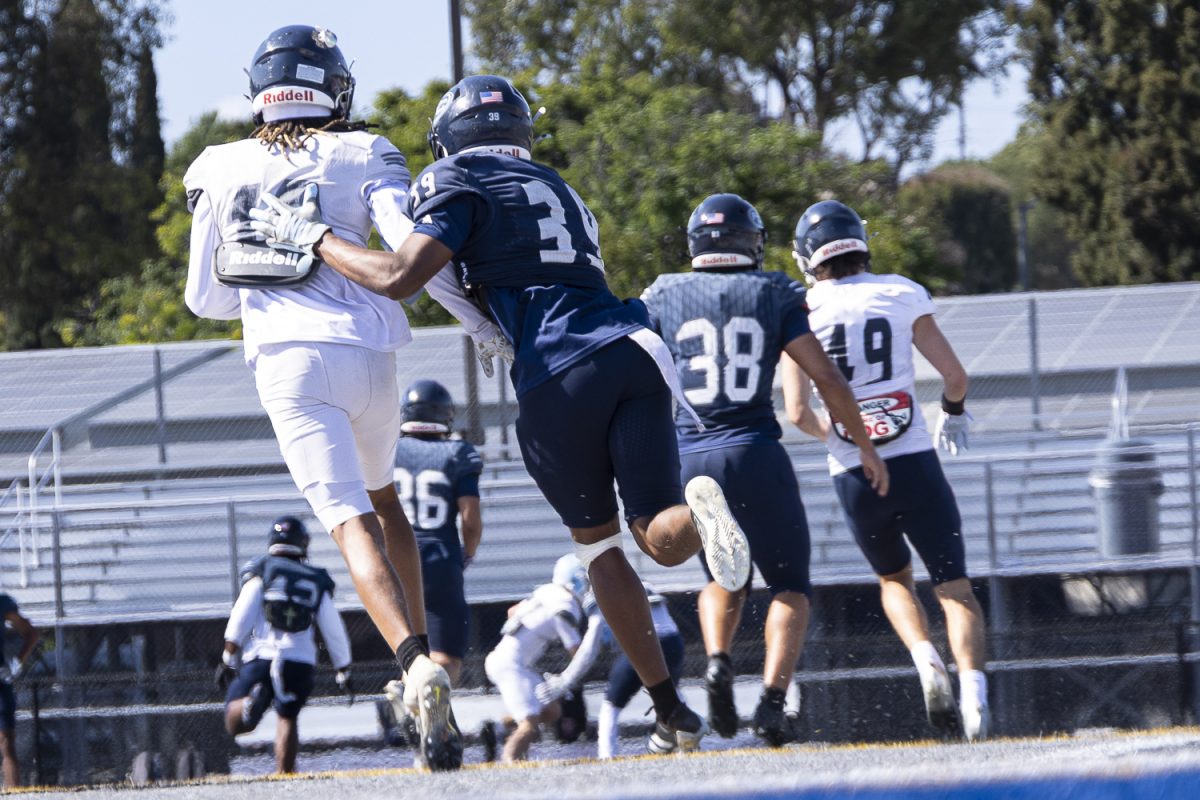Fullerton's Angel Massas (right) and Eric Rory II watch as a pass is completed down the sidelines in a 7-on-7 scrimmage on May 21 in Fullerton, Calif.