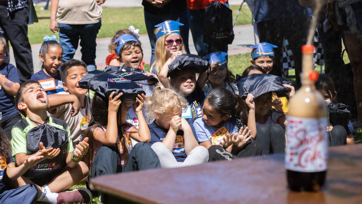 Kindergarteners attending the Kinder Caminata at Fullerton College on April  24, 2026 watch and cover themselves from the soda experiment.